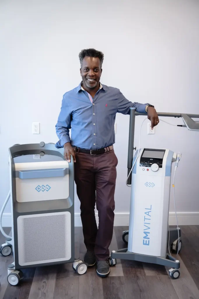 FTG Ortho provider standing between the EMSCULPT NEO and EMVITAL devices