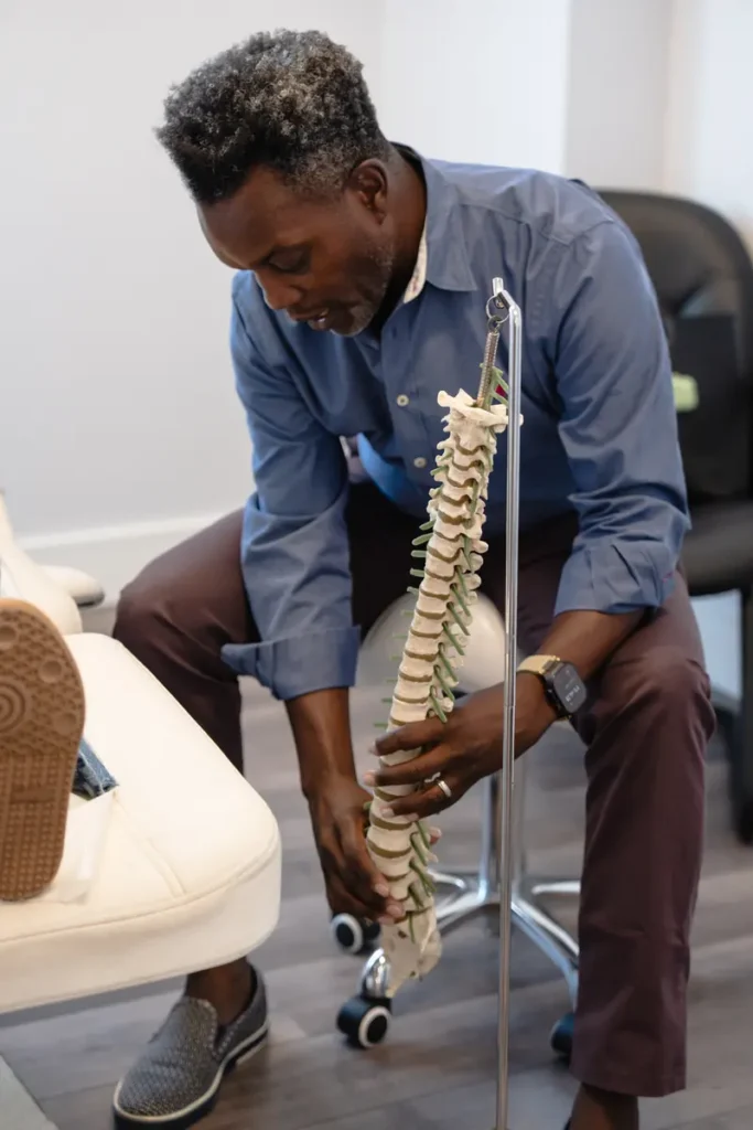 FTG Ortho specialist reviewing a spine model in an Aventura exam room